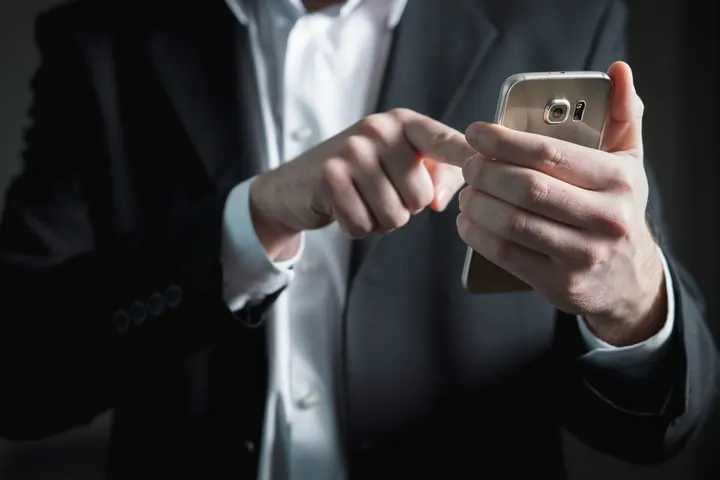 Executivo de terno usando o celular